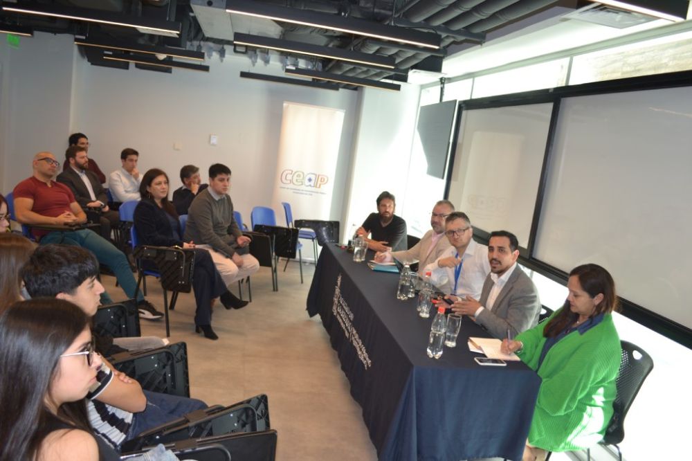 En la imagen se puede ver a un costado derecho la mesa con todos los invitados e invitada, de izquierda a derecha vemos a Daniel Brzovic, Jorgue Thibaut, Antoine Maillet, Luis Orrego y Verónica Figueroa Huencho.